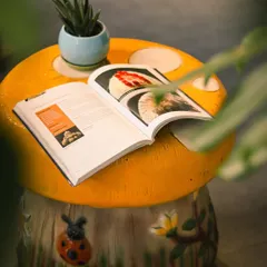 Creating a lazy weekend corner is all about the details. This whimsical, hand-painted mushroom stool serves as a perfect little table for a book and a small succulent in a blue ceramic pot.
