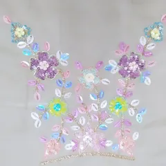 This image shows a neckline motif created with multi-colored sequins and beads. This kind of detailed hand-embroidery allows me to create completely custom patterns that reflect your personal style and the theme of your event.