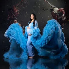 Create your own fairytale moment in my studio. This expecting mother looks absolutely radiant in a sky-blue maternity gown with dramatic ruffled sleeves, creating a beautiful reflection in the water. My studio setups are designed to bring your most magical ideas to life.