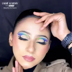 A student's work featuring a multi-color graphic eyeshadow look. The smooth gradient from blue to green and the clean lines demonstrate excellent control and blending skills.