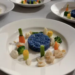 This dish was inspired by the vibrant, stacked sculptures of artist Annie Morris. We translated her use of color and form onto the plate with this striking blue rice, surrounded by meticulously placed seasonal vegetables. It’s a dish that’s both a meal and a piece of art.