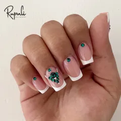 A classic French manicure on square extensions gets a glamorous upgrade. I've added a stunning cluster of green Swarovski crystals on the ring finger for a pop of color and sparkle.