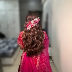 Adding a touch of floral magic with this half-updo featuring a cascade of pink flowers over long, flowing waves.
