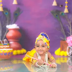 Another joyful shot of our Little Krishna, smiling brightly for the camera. The colorful and detailed setup perfectly captures the spirit of Janmashtami.