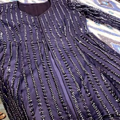 A close-up of a navy blue peplum-style kurti with vertical lines of silver beadwork. This is a great design for a party wear suit.
