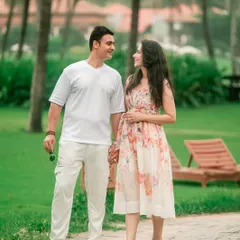 A relaxed walking shot of a couple hand-in-hand through a beautiful garden, capturing a natural and happy interaction.