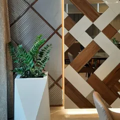 A geometric white planter holding a ZZ plant, chosen for its modern look and low-light tolerance. This type of plant styling is ideal for corporate interiors, adding a touch of sophisticated green to reception areas or lounges.
