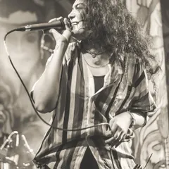 A black and white shot of Dhruvi, our lead female vocalist, lost in the song. She brings the power and soul to every performance.