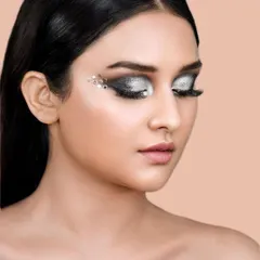 A close-up beauty shot showcasing a dramatic silver eye makeup look with crystal embellishments. This type of detailed work is ideal for makeup artists' portfolios and cosmetic campaigns.