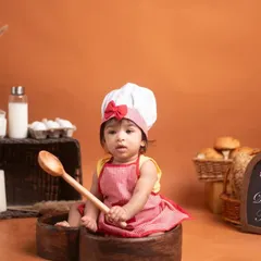 A wider view of the 'Little Chef' setup, complete with a personalized chalkboard, baking ingredients, and a half-birthday sign. These details help create a complete story for your baby's milestone session.