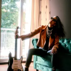 Here, I'm channeling my inner rock star. This edgy look, complete with a biker jacket and an electric guitar, shows my ability to embody a completely different persona for brands looking for a bold, rock and roll vibe.