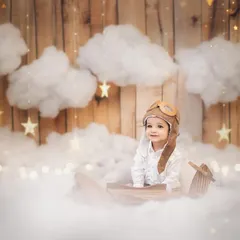 A sweet, curious glance from our birthday boy in his pilot gear. These themed sessions are designed to be fun and engaging for the baby, allowing me to capture their natural expressions.