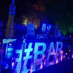 Another view of the blue LED bar, showing the full length of the counter. The setup includes ample space for glassware, drink preparation, and decorative elements like the bottle-shaped wire art.