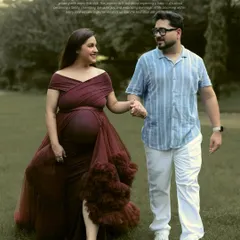 An outdoor session allows us to capture love in its most natural form. Here, an expecting couple shares a quiet moment while walking through a park, the flowing gown adding a touch of romance to the serene landscape.