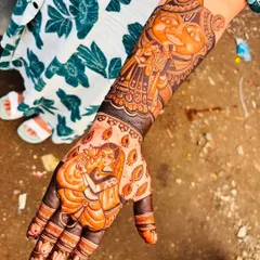 This design features a full portrait of Lord Ganesha on the back of the hand, along with a depiction of a bride and groom, blending divine blessings with wedding themes.