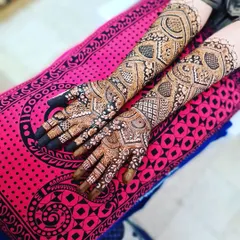 An elegant and intricate design perfect for an engagement party. The pattern extends up the arms with beautiful, flowing motifs.