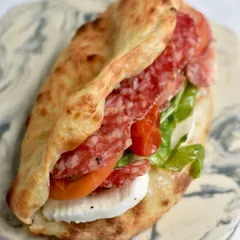 Our Ibérico Sausage Sourdough Pizza Sandwich, a star from our Spanish popup. We layer a freshly baked sourdough flatbread with premium Ibérico sausage, roasted tomatoes, capers, and fresh mozzarella.
