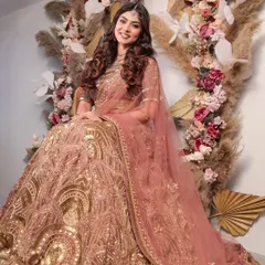 A full-length view of the dusty pink and gold lehenga, showcasing its intricate gold patterns and flowing silhouette. It’s a regal yet understated option for any bride-to-be.