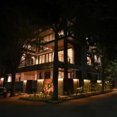 Another angle of the beautifully lit exterior of 'The Nest' project at night.
