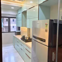 A view of the refrigerator and upper cabinets in our Ghatkopar project. The textured glass finish adds a unique touch to the overall design.