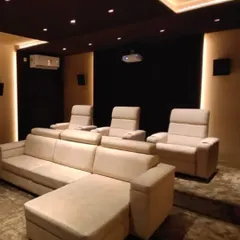 Comfort is key for any cinema experience. This setup combines a plush L-shaped sofa with dedicated recliners, offering flexible seating for the whole family. The two-tier layout ensures everyone has a perfect, unobstructed view of the screen.