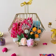 This unique metal hexagon birdcage box is a true statement piece. It's filled with laddoo candles, flowers, and other festive items.