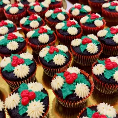A tray of my Christmas-themed cupcakes, decorated with holly and berry designs. These were a holiday season favorite, perfect for festive gatherings.