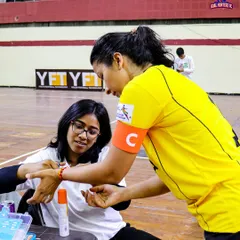 Our medical staff providing on-site first aid to a player during a futsal match.