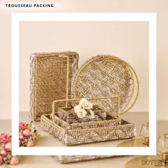 For a cohesive look, I provide matching sets of trousseau packing materials. This collection includes woven baskets and trays in various shapes and sizes, all sharing a beautiful gold and white pattern.