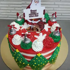 Wishing everyone a very Merry Christmas with this festive cake. It's decorated with red and green buttercream, silver bells, and a Santa topper, capturing all the joy of the holiday season.