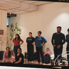 An instructor leads a group discussion in our studio. We foster an atmosphere where everyone feels heard and valued, allowing for deep growth and shared learning as a collective.