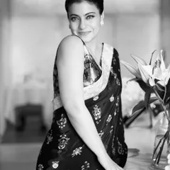 A timeless black and white portrait of Kajol, capturing her classic beauty in an intricately embroidered dark saree.