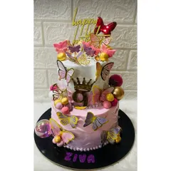 A magnificent two-tiered butterfly cake for a 9th birthday. This pink and white design is covered in beautiful, colorful butterflies and topped with a crown.