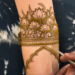 Here you can see me adding the final touches to a lotus arm band design. The fine tip of my cone allows for very detailed work.