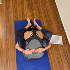 An overhead view of a student in Baddha Konasana (Bound Angle Pose) with a forward fold. This posture deeply opens the hips and inner thighs.
