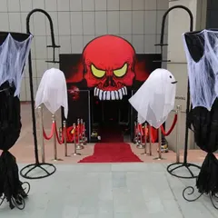 For a truly immersive Halloween party, we designed this spooky entrance. It features a giant skull backdrop, hanging ghost figures, and a red carpet walkway to set a dramatic and haunted tone right from the start.