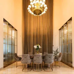 This double-height dining area in a Bangalore villa showcases our ability to create dramatic and elegant spaces. We used custom fluted glass partitions and a grand crystal chandelier to define the space while maintaining an open, airy feel perfect for hosting.
