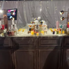 We love adding a bit of drama to our bar setups. This bar features an impressive display of cocktails enhanced with a theatrical dry ice smoke effect, creating an instant 'wow' factor for arriving guests.