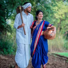This shot captures the essence of the Marathi Shetkari theme, with the couple standing proudly in a field. The use of traditional props like the hoe and copper pot adds a layer of authenticity to their story.