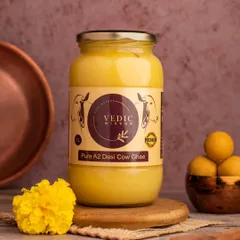 A product shot for Vedic Wisdom's Pure A2 Desi Cow Ghee. We styled it with traditional elements like a copper vessel and marigold flowers to convey purity, tradition, and quality.
