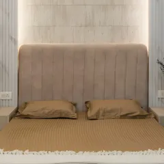 Luxury lies in the details. This bedroom features a plush, channel-tufted headboard in a soft beige fabric, with backlighting that creates a warm and inviting glow.
