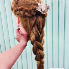 Practicing a crown braid that flows into a rope braid. This romantic hairstyle is perfect for a pre-wedding shoot or a bohemian-themed event.