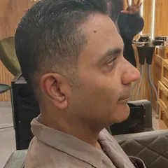 A sharp and clean haircut for men. This side profile shows the precision of the fade and the neat styling on top.