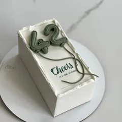 A modern and stylish cake for a 42nd birthday, featuring olive green balloon numbers.