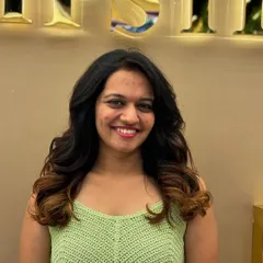 A smiling client with a fresh ombré hair color. The transition from dark to light is smooth and natural, giving her a stylish and modern look.
