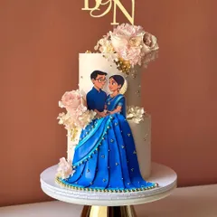 The full view of the stunning Indian couple engagement cake on a golden stand.