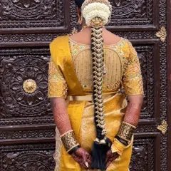 A beautiful bridal braid for a traditional wedding ceremony. The hairstyle features a neat plait decorated with delicate pearl and gold Jada Billa, complemented by a jasmine gajra at the top.