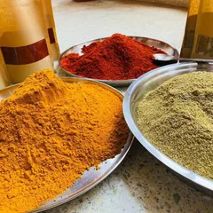 The secret to authentic flavor is in the spices. I source these vibrant, hand-ground masalas directly from Rajasthan. You can see the rich color and texture of the turmeric, red chili, and coriander powders.