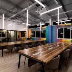 This open-plan workspace features a custom installation of suspended LED tubes. The arrangement is designed to provide excellent, uniform light for working while creating a sense of energy and movement that reflects a modern, dynamic company culture.
