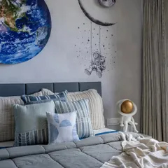 A close-up of the space-themed kids' room, featuring a vibrant Earth mural and an astronaut swinging from the moon. It's a design that fuels imagination and curiosity.